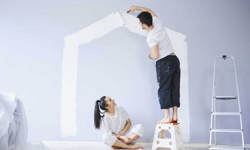 couple-painting-house-shape-on-wall-in-new-apartment.jpg